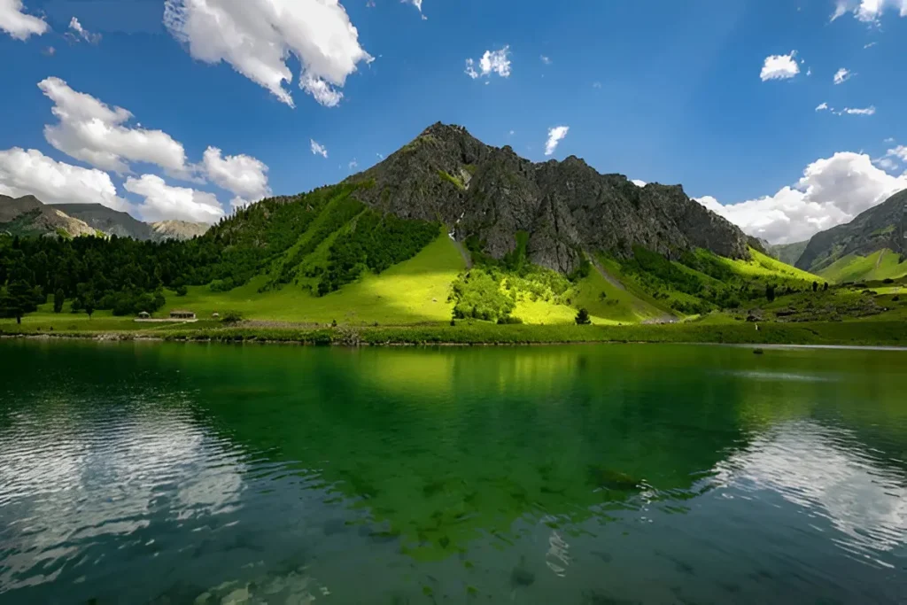the lake-and-mountain hero reads “Green mountain reflected in a clear alpine lake in Minimarg Valley under blue sky”. The pavilion photo and the signboard photo each have their own descriptive alt text.