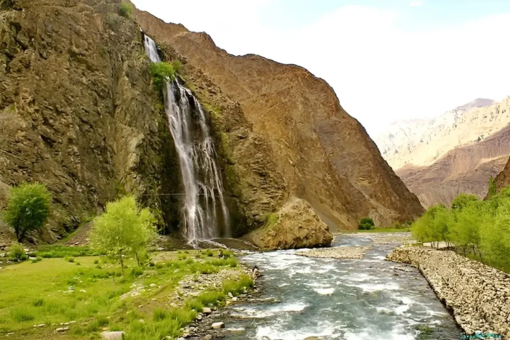 Manthokha Waterfall falling down a dark rock face into a rocky stream in Kharmang Valley, Gilgit-Baltistan