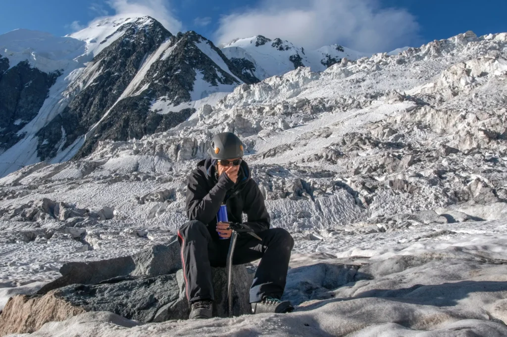 Altitude sickness Karakoram trek: two trekkers with packs crossing a snowy glacier